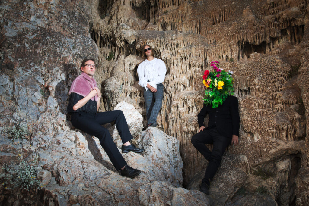 Lovers Of All Kinds band. Sebastian Boulter, Jaakko Eino Kalevi & Teemu Mutual posing in front of stalagmite.